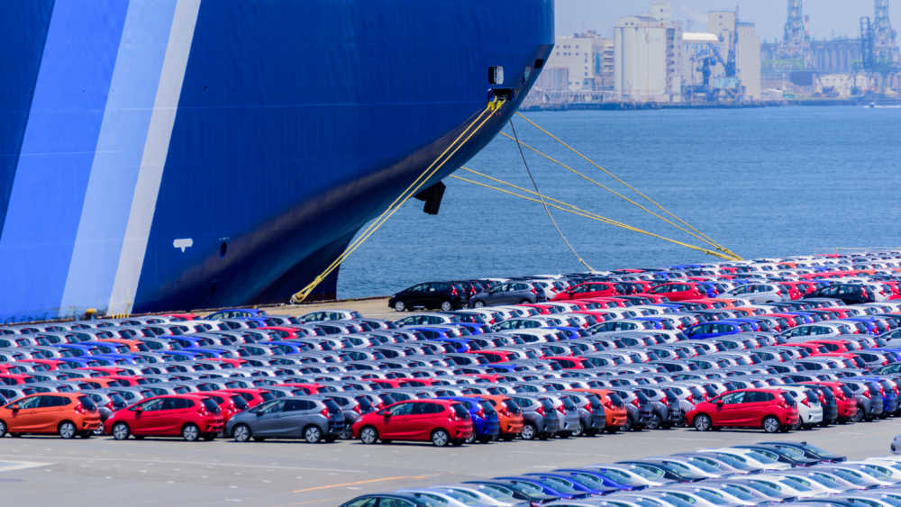 Cars lined up in front of a ship, ready to be exported